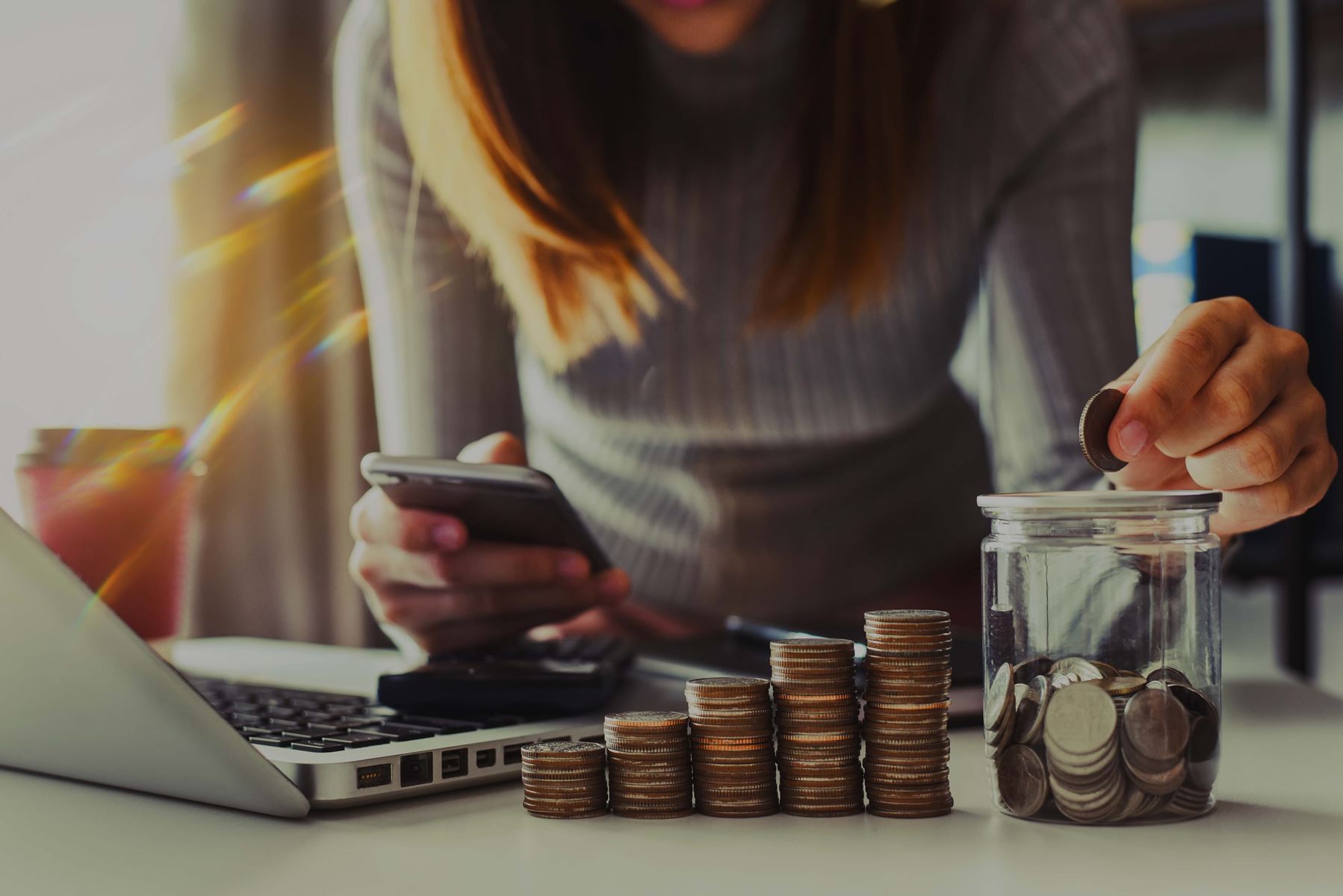 Woman counting coins while using phone