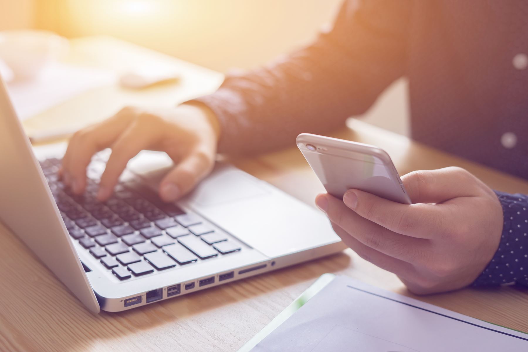 Woman using phone with a computer